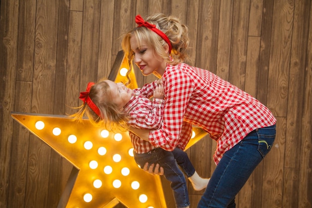 Foto bella madre e figlia in stile pinup si divertono ad abbinare i vestiti per madre e figlia