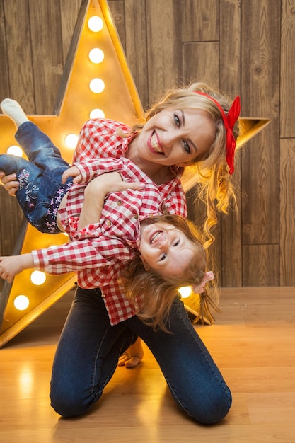 Foto bella madre e figlia in stile pinup si divertono ad abbinare i vestiti per madre e figlia