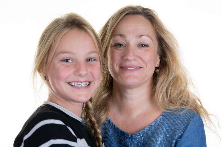 Beautiful mother and daughter smiling - isolated over a white background