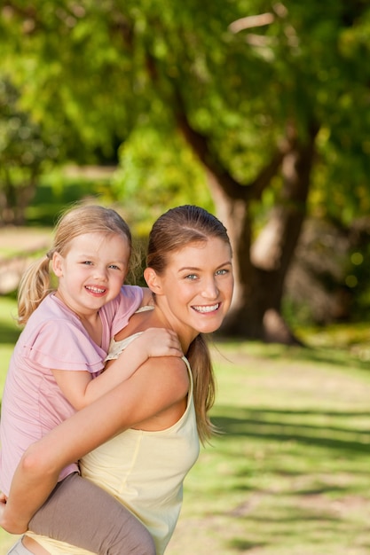 Beautiful mother giving daughter a piggyback