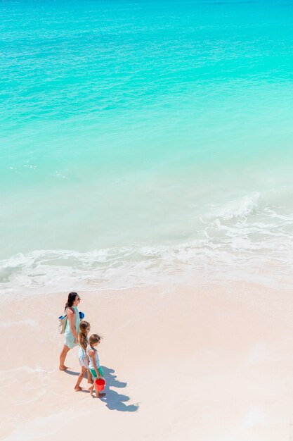 Beautiful mother and her adorable little daughter at beach