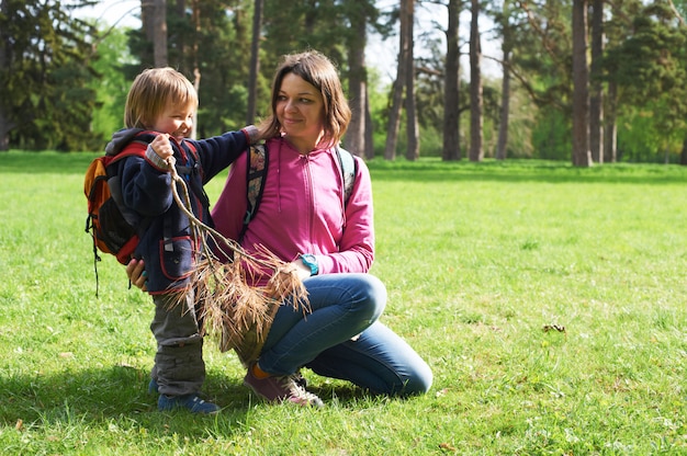 Beautiful mother and her cute son walking in the park