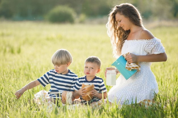 Beautiful mother and her sons having a picnic