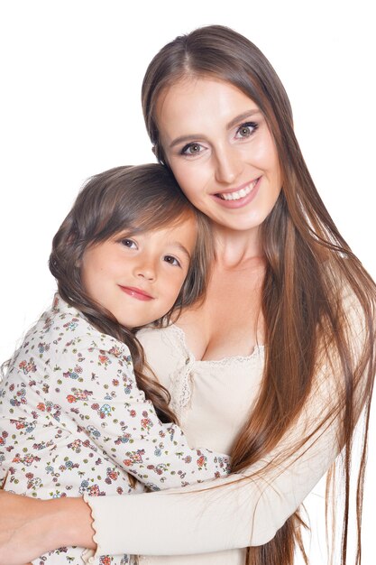 Beautiful mother hugs her daughter on a white background