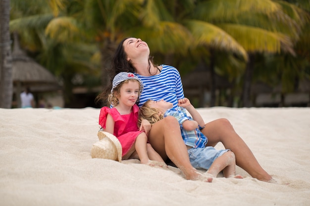 Beautiful mother and two kids enjoying beach vacation