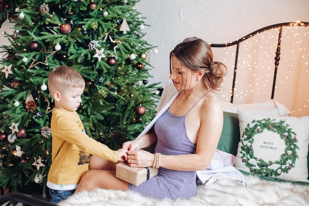 Beautiful mothere helps to unpacks present for her child