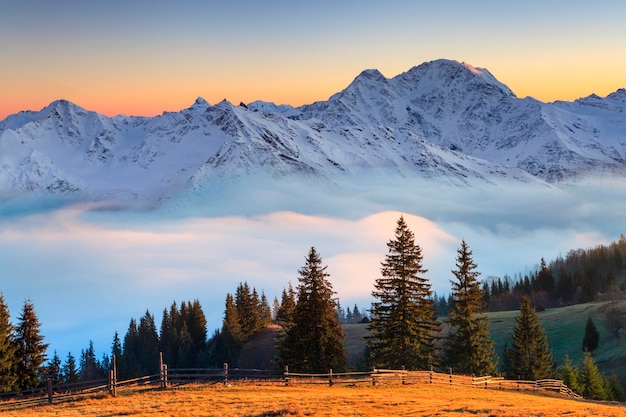 Красивый горный пейзаж в туманном восходе солнца Альпах Австрии