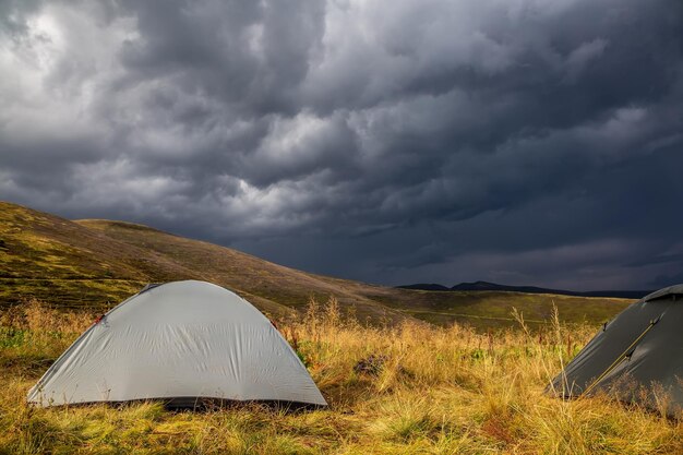 Beautiful mountain landscape in stormy weather with a tourist tent Carpathian mountains of Ukraine Holidays in the mountains