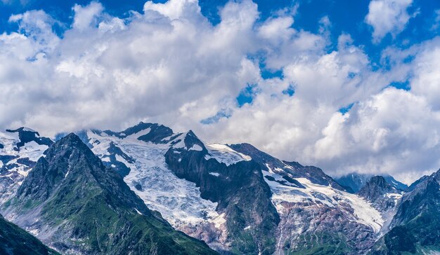 夏の美しい山の風景曇りの天気で雪が降る強大な山々