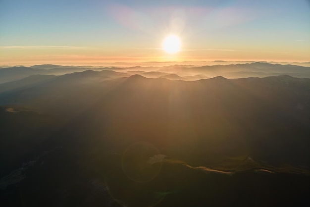 夕暮れ時のかすんだ峰と霧の谷を持つ美しい山のパノラマ風景