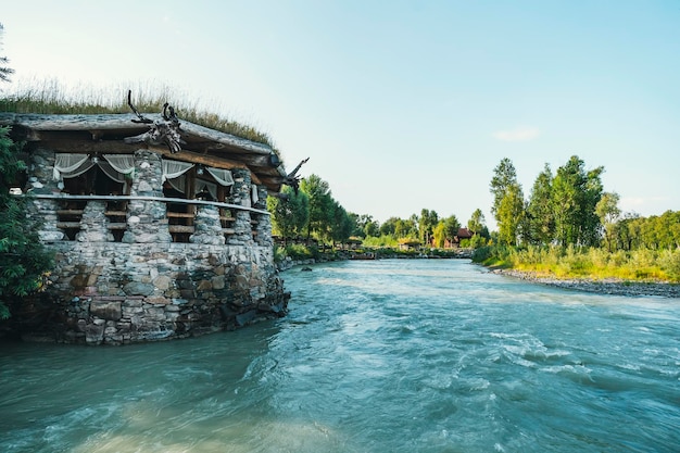 青緑色の水と美しい山の川の風景観光客のための川のほとりにある石造りの建物のレストラン