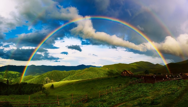Foto splendida valle di montagna con verdi colline e un enorme arcobaleno in estate. sfondo naturale di viaggio all'aperto. carpazi, ucraina