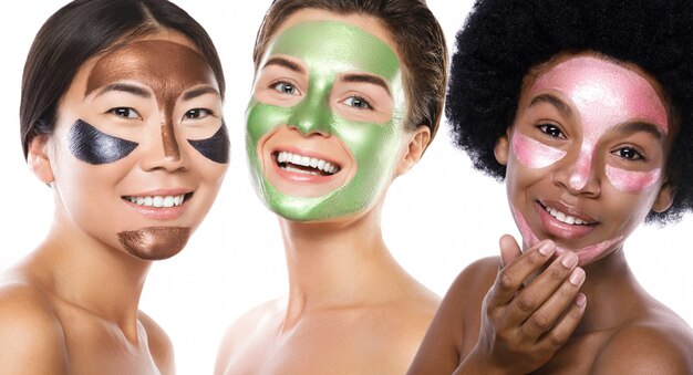 Beautiful multi-ethnic girls with colorful peel-off masks on their faces