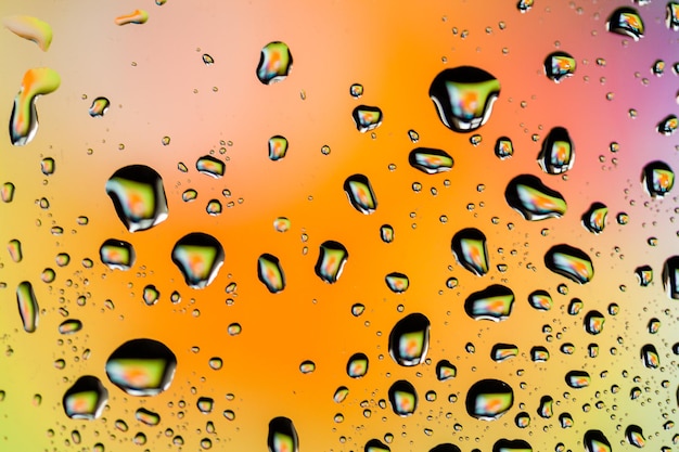 Beautiful multicolored water droplets on a glass