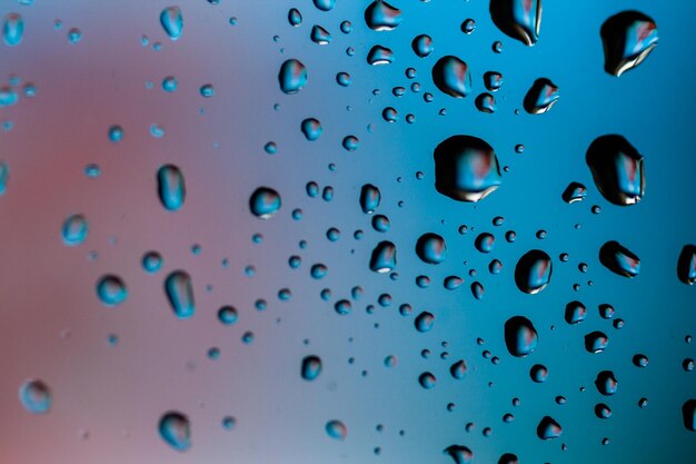 Beautiful multicolored water droplets on a glass