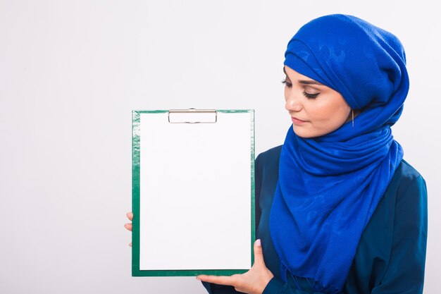 Beautiful Muslim fashion girl holding an empty banner, copy-space.