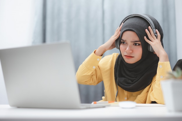 집에서 온라인 학습 랩톱 컴퓨터를 사용하여 아름다운 이슬람 학생 소녀. 원격 교육 온라인 교육.
