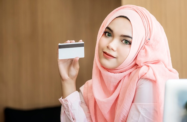 beautiful muslim woman holding credit card