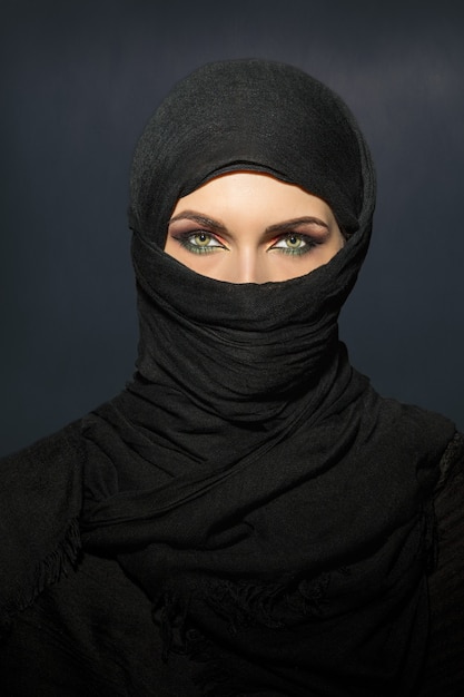 Photo beautiful muslim woman in niqab traditional veil against on dark background