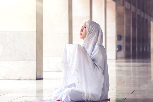 Beautiful muslim woman praying in the mosque