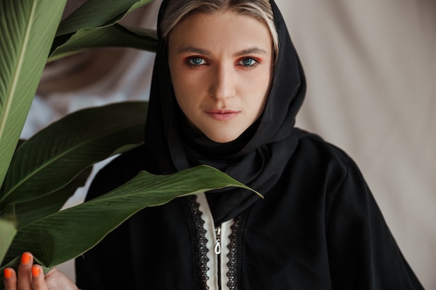 회색 배경에 전통적인 아라비아 아바야 드레스를 입은 아름다운 이슬람 여성