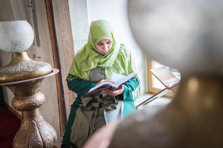 Photo 聖なる本コーランを読んでモスクの中の美しいイスラム教徒の若い女性