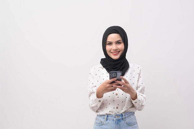 Beautiful musllim woman with hijab using smartphone over white background technology concept x9x9