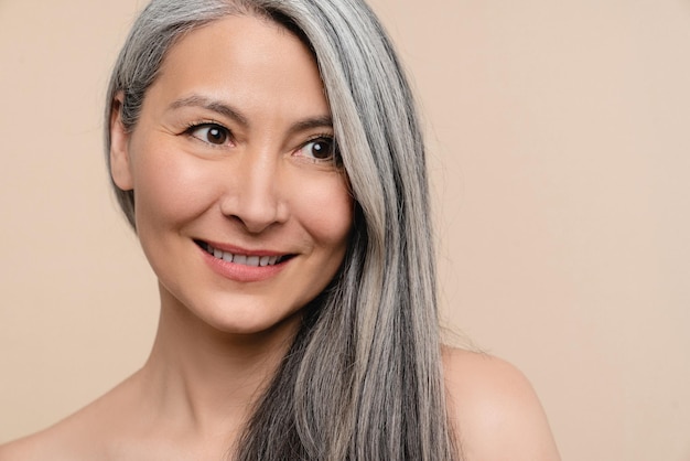 Beautiful naked shirtless mature middleaged woman with long\
grey hair hair care and treatment