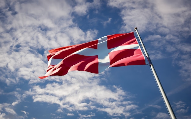 Beautiful national state flag of Denmark fluttering on blue sky