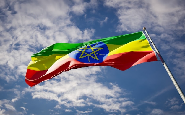 Beautiful national state flag of Ethiopia fluttering on blue sky