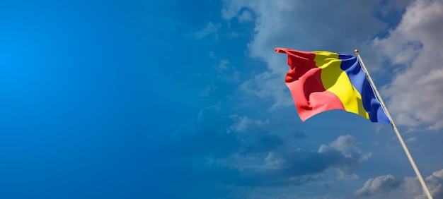 Beautiful national state flag of Romania on blue sky