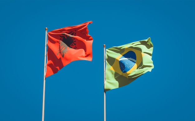 Photo beautiful national state flags of brasil and albania together on blue sky