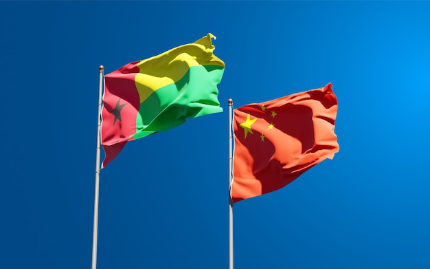 Beautiful national state flags of China and Guinea-Bissau together at the sky 