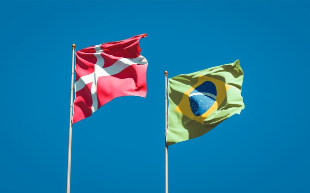 Beautiful national state flags of Denmark and Brasil together on blue sky