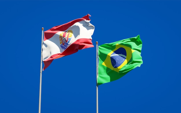 Beautiful national state flags of French Polynesia and Brasil together on blue sky