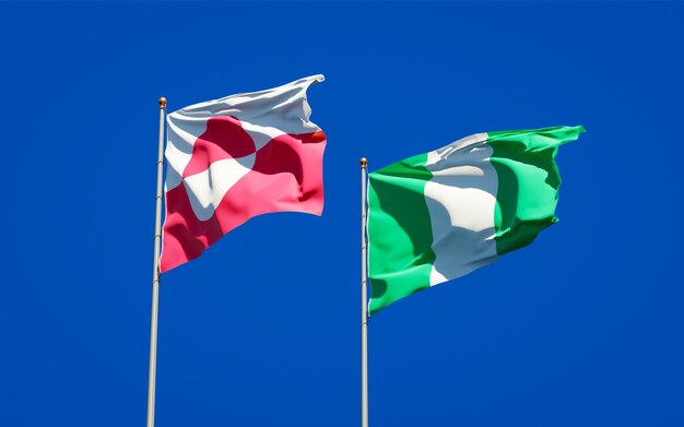 Beautiful national state flags of Greenland and Nigeria together on blue sky