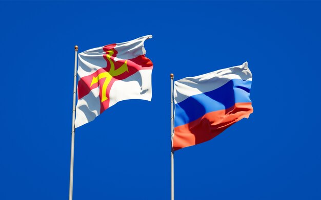 Beautiful national state flags of Guernsey and Russia together on blue sky. 3D artwork