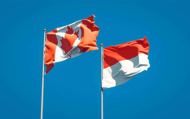 Beautiful national state flags of Indonesia and Canada together on blue sky