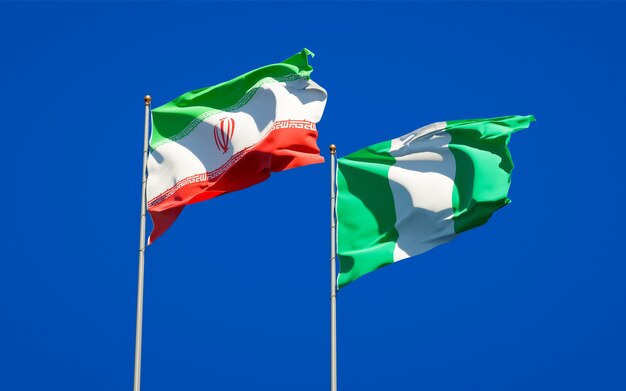 Beautiful national state flags of Iran and Nigeria together on blue sky