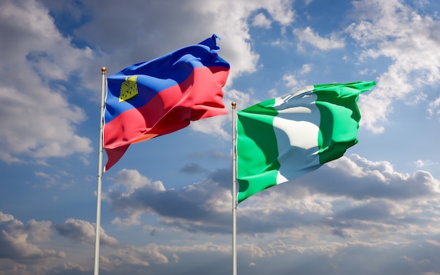 Belle bandiere di stato nazionali del liechtenstein e della nigeria insieme sul cielo blu