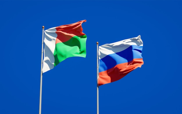 Beautiful national state flags of Madagascar and Russia together on blue sky. 3D artwork