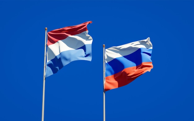 Beautiful national state flags of Netherlands and Russia together on blue sky. 3D artwork