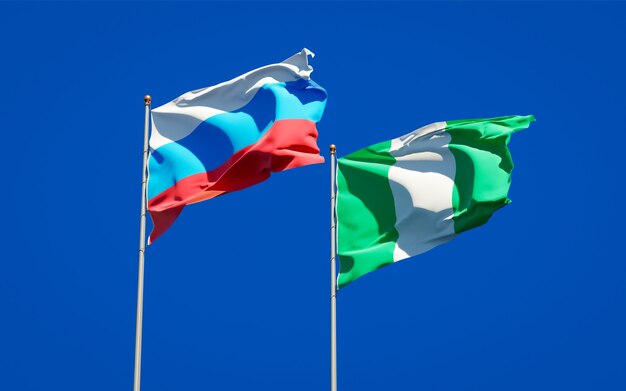 Beautiful national state flags of New Russia and Nigeria together on blue sky