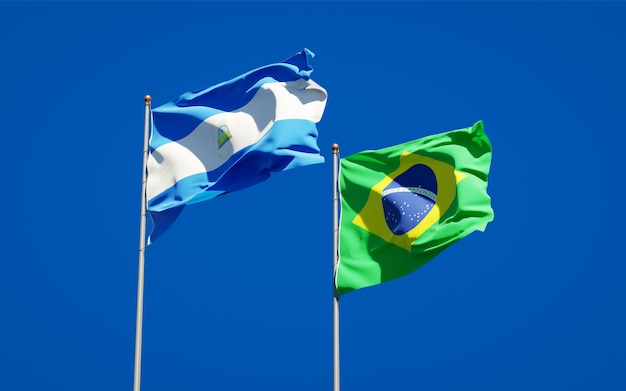 Beautiful national state flags of Nicaragua and Brasil together on blue sky