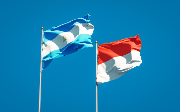 Beautiful national state flags of Nicaragua and Indonesia together on blue sky