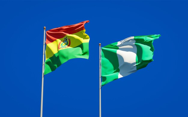 Belle bandiere dello stato nazionale della nigeria e della bolivia insieme sul cielo blu