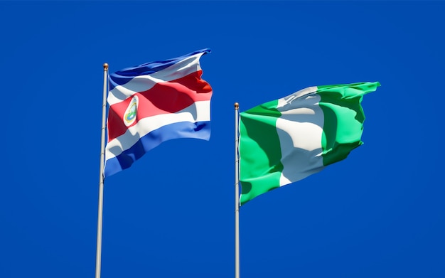 Belle bandiere di stato nazionali della nigeria e della costa rica insieme sul cielo blu