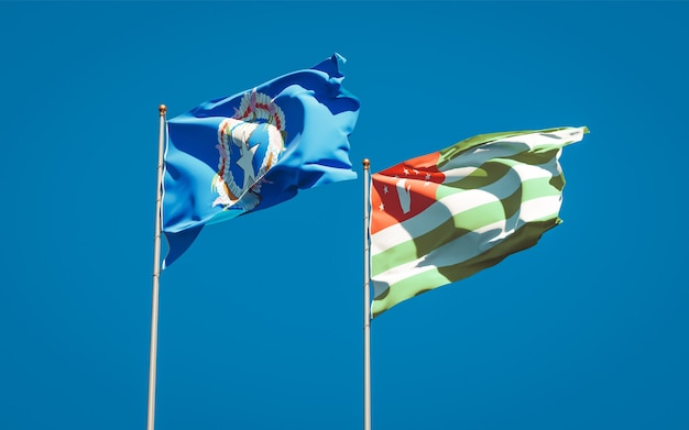 Красивые национальные государственные флаги Северных Марианских островов и Абхазии вместе на голубом небе. 3D изображение