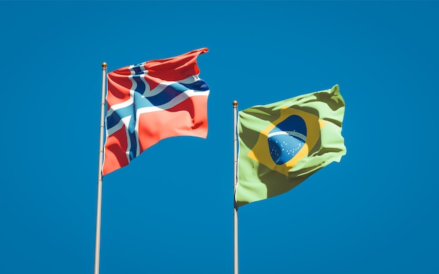 Beautiful national state flags of Norway and Brasil together on blue sky