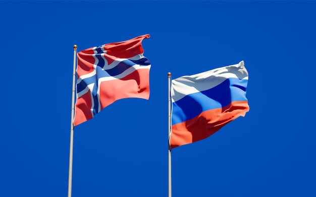 Beautiful national state flags of Norway and Russia together on blue sky. 3D artwork